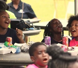 A group of kids laughing at a table.