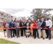 A group of people gather to cut a ribbon.