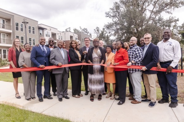 A group of people gather to cut a ribbon.